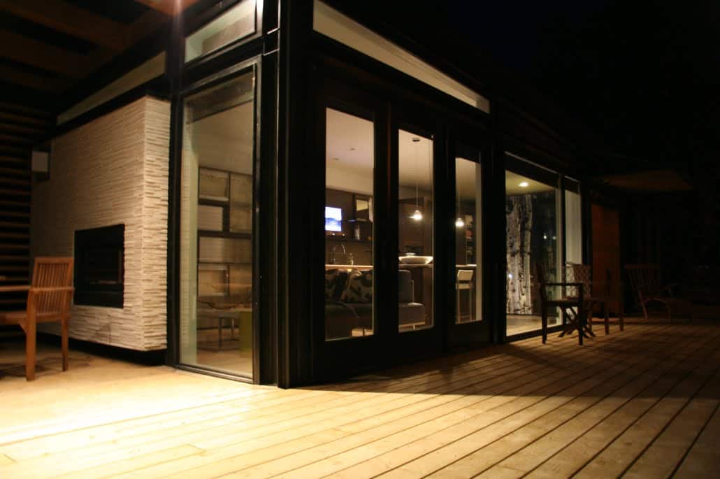 The Bow prefab home - deck and exterior at night.